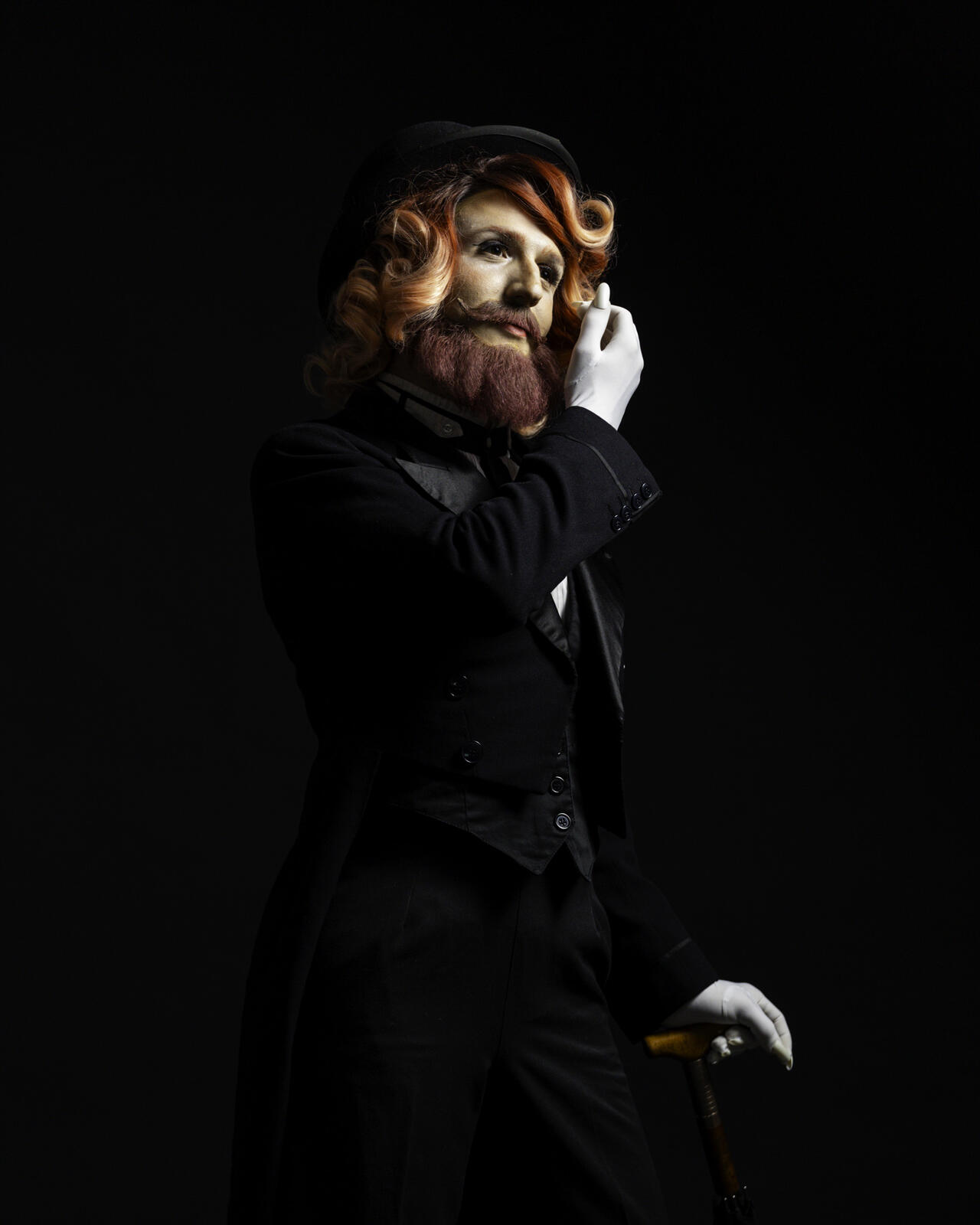 René.e drag queer en homme classe. Portrait sur fond noir