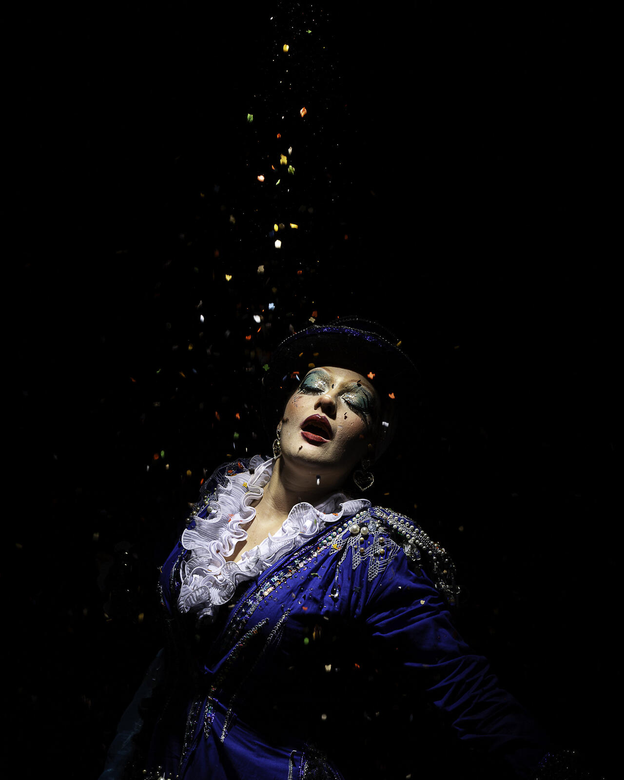 Drag queen avec confettis sur fond noir